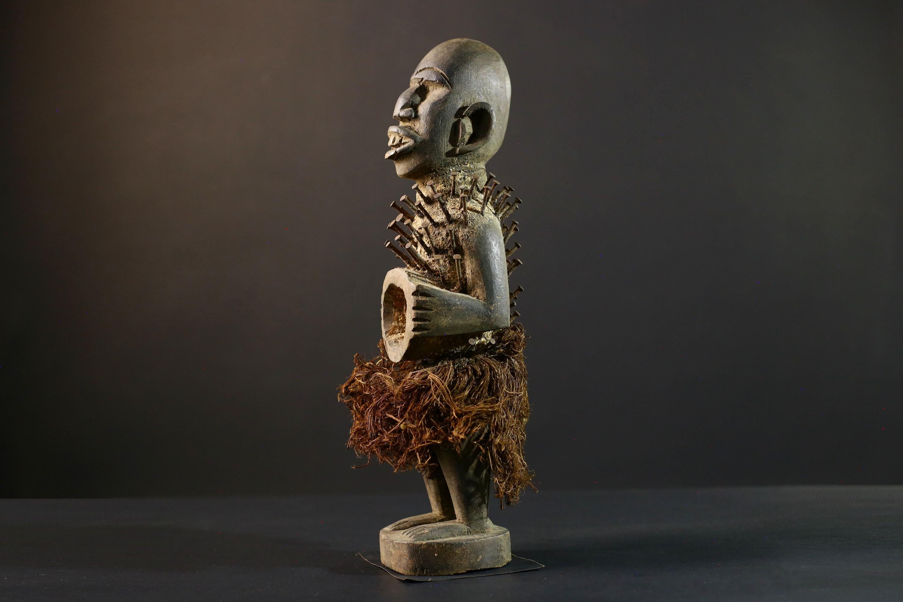 African Nkisi Nkondi nailed fetish statue Congo power figure tribal charm carved wood ritual art protective totem cavity raffia skirt-G5371