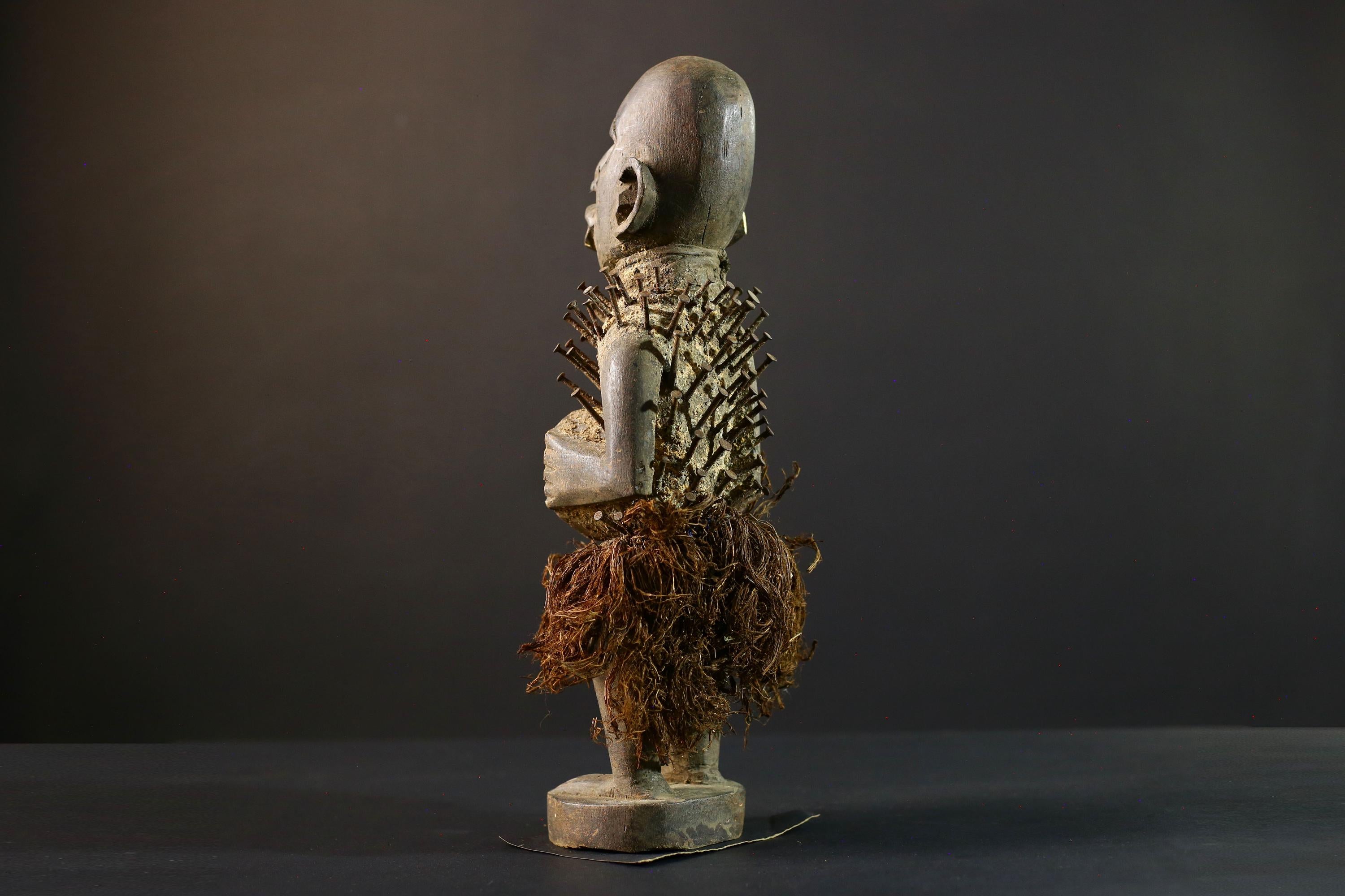 African Nkisi Nkondi nailed fetish statue Congo power figure tribal charm carved wood ritual art protective totem cavity raffia skirt-G5371