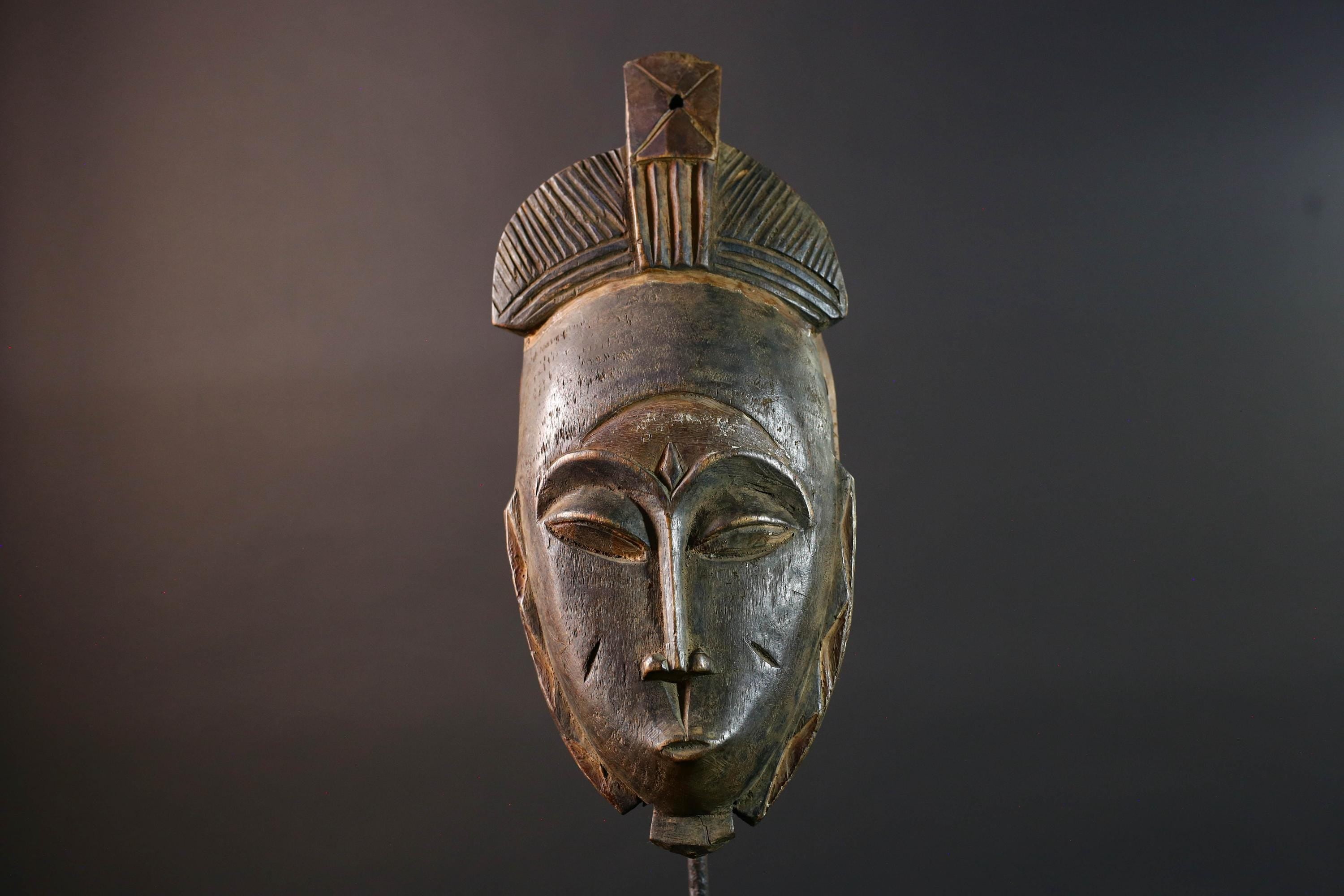 African wall decor Baule tribal mask with downcast eyes geometric accents and tall domed crest for symbolic interior statement piece G5498