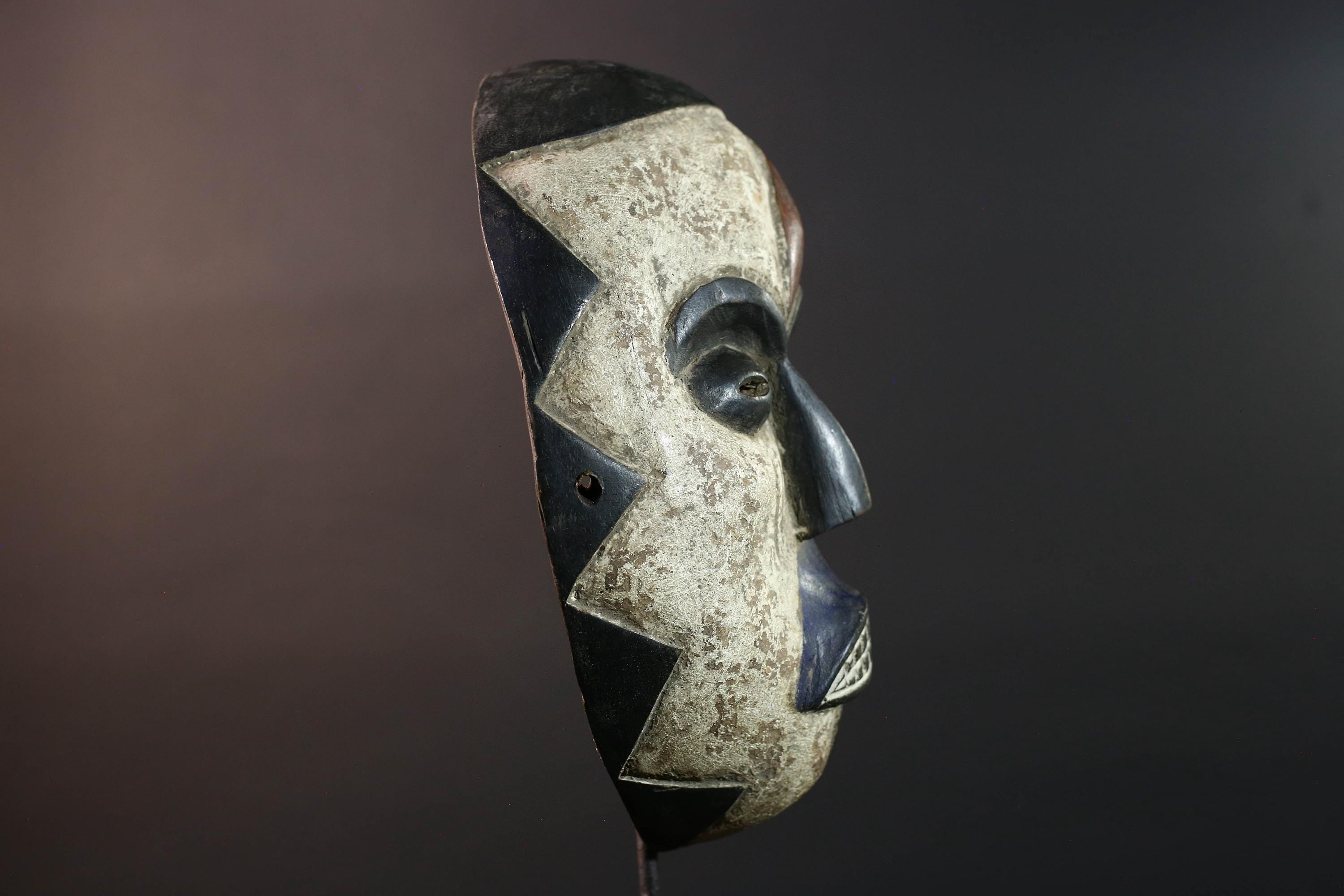 African wall decor Dan tribal mask with red white and blue split face carved features and symbolic teeth for expressive rustic display G5501