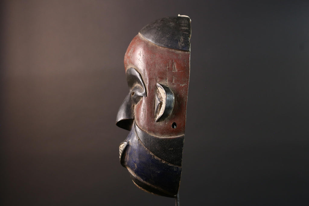 African wall decor Dan tribal mask with red white and blue split face carved features and symbolic teeth for expressive rustic display G5501