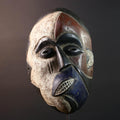 African wall decor Dan tribal mask with red white and blue split face carved features and symbolic teeth for expressive rustic display G5501
