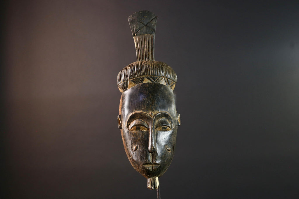 Africa tribal wall mask Baule carving with tall ridged crest narrow face and symbolic cheek marks for spiritual interior statement art G5502