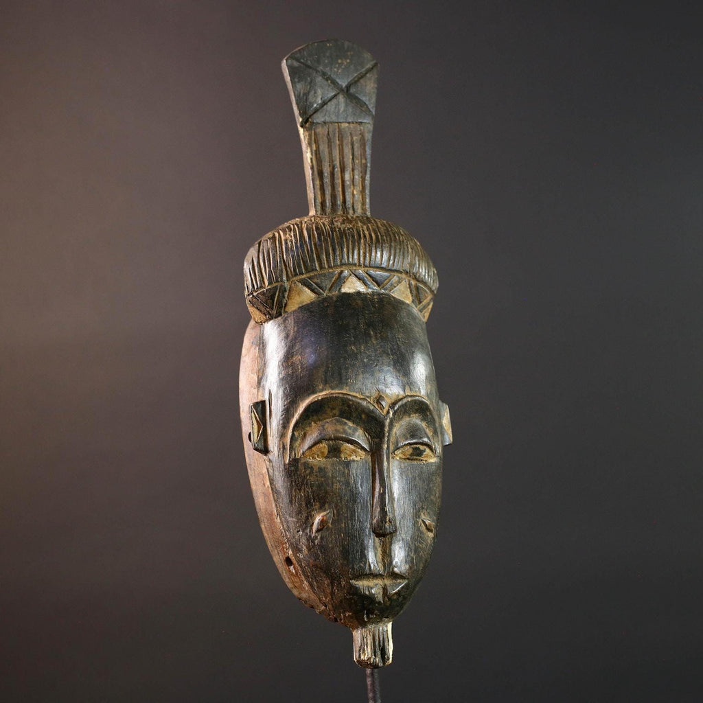 Africa tribal wall mask Baule carving with tall ridged crest narrow face and symbolic cheek marks for spiritual interior statement art G5502