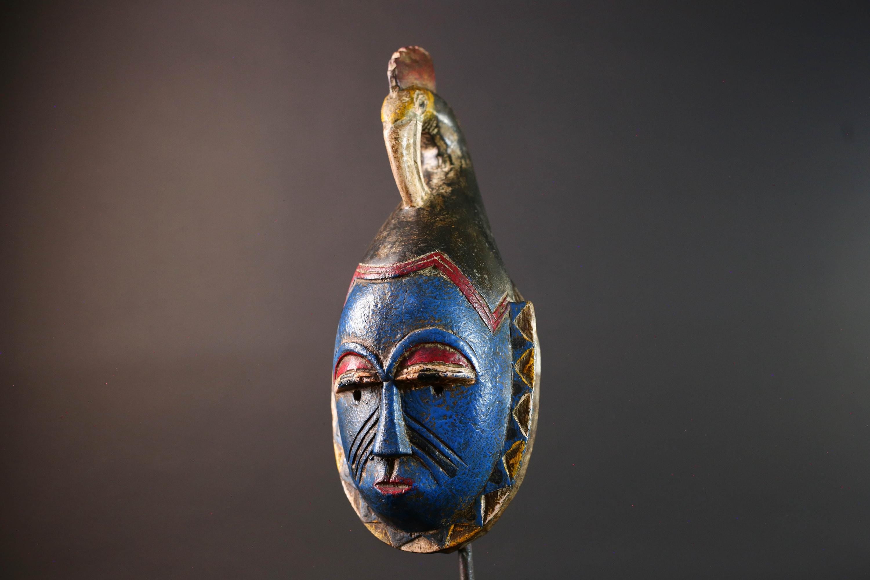 African tribal mask Guro carved wood wall decor with blue face bird crest scarification red white eyelids artisan symbolic sculpture-G5517