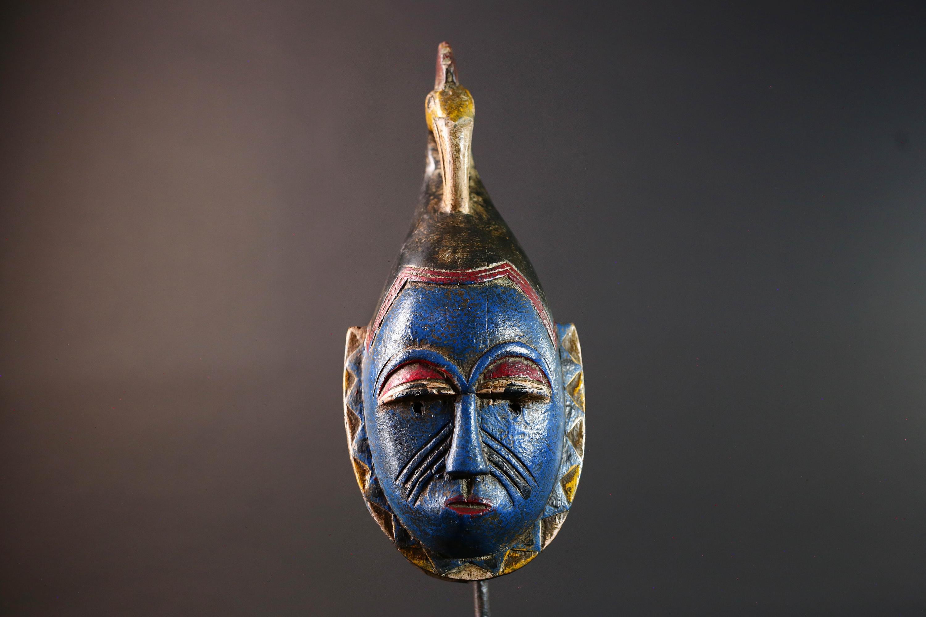 African tribal mask Guro carved wood wall decor with blue face bird crest scarification red white eyelids artisan symbolic sculpture-G5517