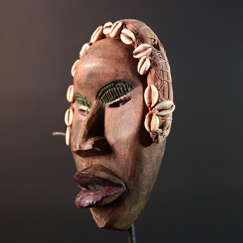 African mask Dan cowrie headdress with green eyelids, red lips, and carved wood female spirit face from Côte d’Ivoire wall art G5575