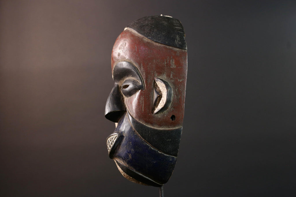 African wall decor Dan tribal mask with red white and blue split face carved features and symbolic teeth for expressive rustic display G5501
