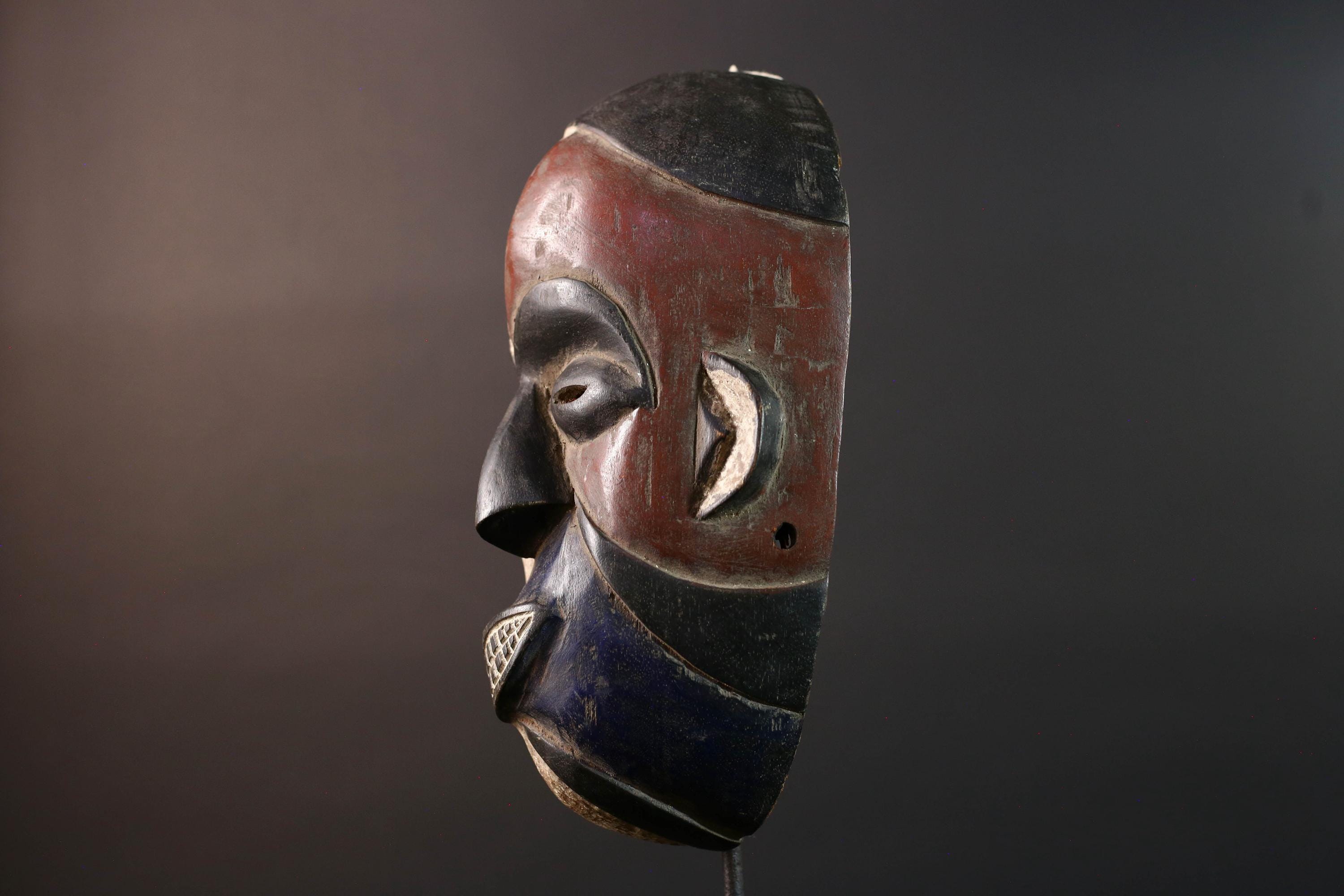 African wall decor Dan tribal mask with red white and blue split face carved features and symbolic teeth for expressive rustic display G5501