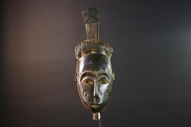 Africa tribal wall mask Baule carving with tall ridged crest narrow face and symbolic cheek marks for spiritual interior statement art G5502
