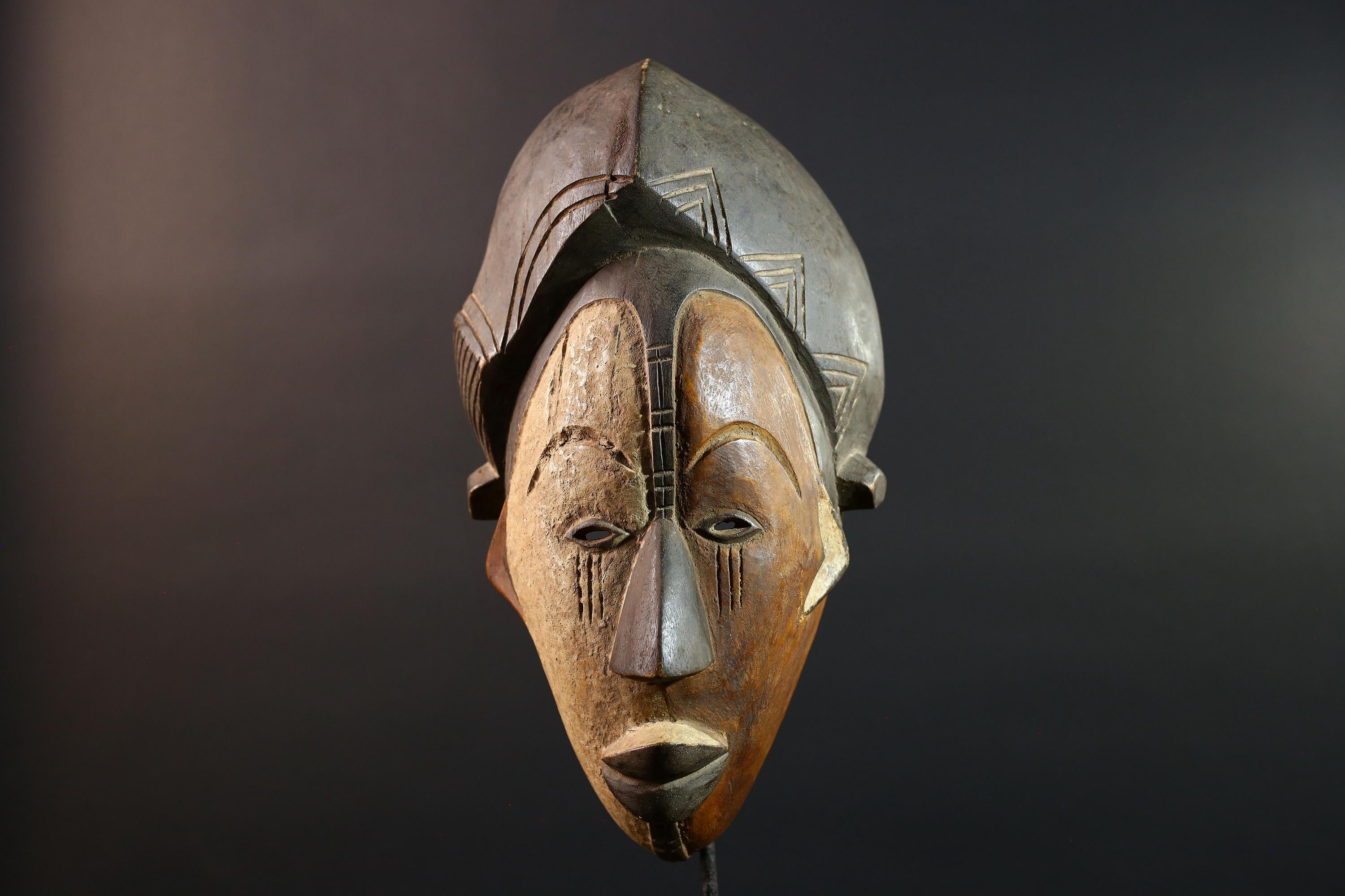 Hand carved African Punu mask tribal wall decor with kaolin white face and tall braided crest art from Central Africa G5569