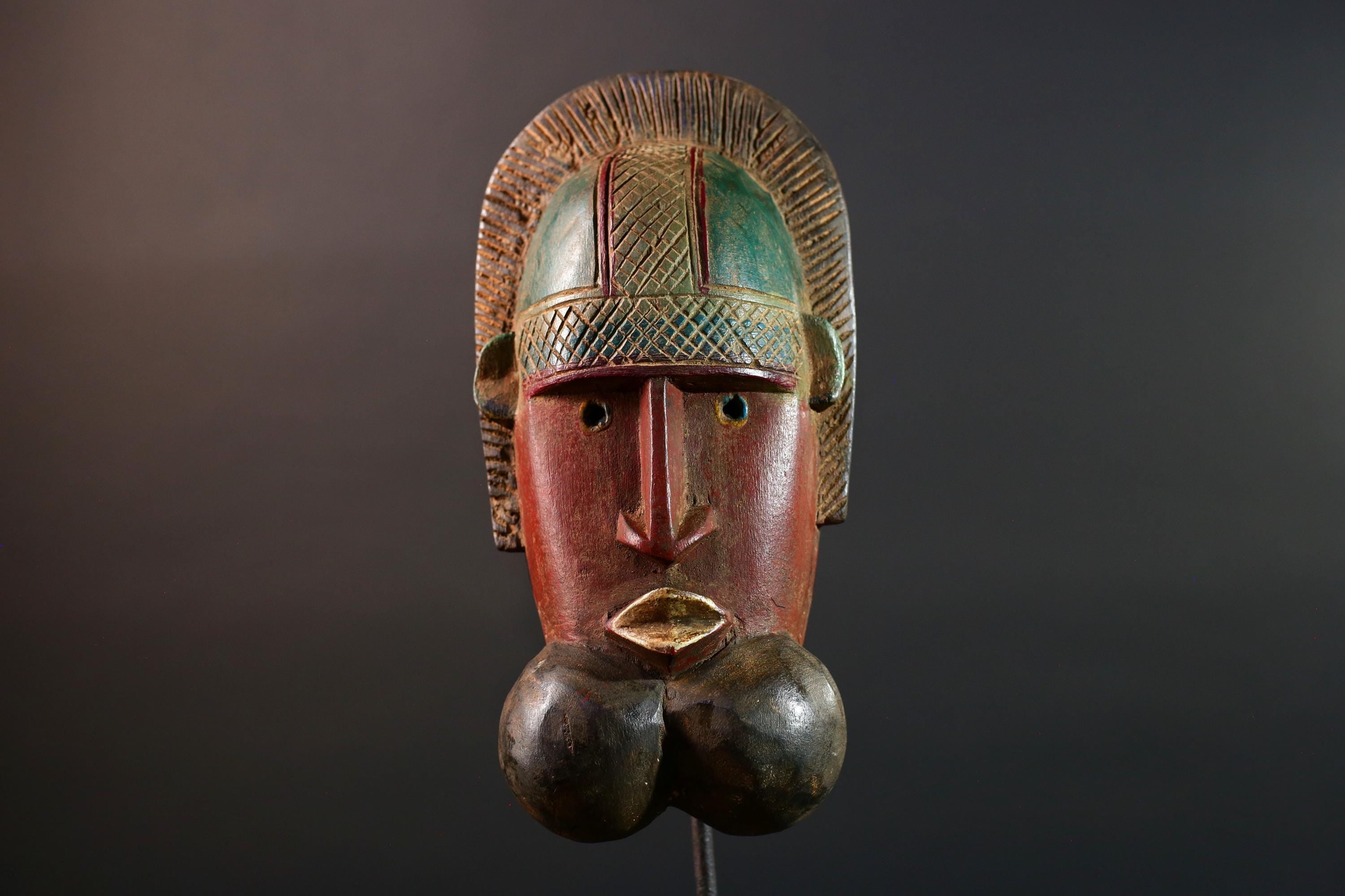 African mask Songye tribal decor with carved geometric features, red angular face, and bold cheek shapes wall hanging sculpture G5572