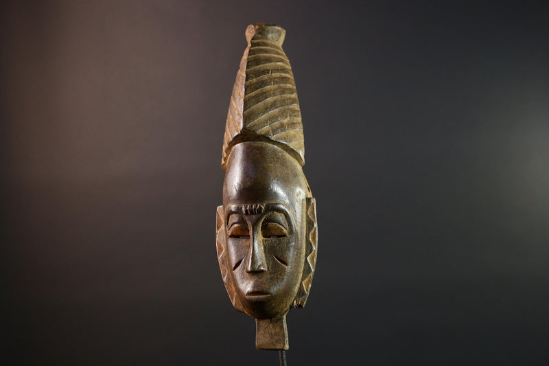 African mask Baule tribal art with long oval face, downcast eyes, vertical ridged crest, and carved cheek marks wall decor sculpture G5573