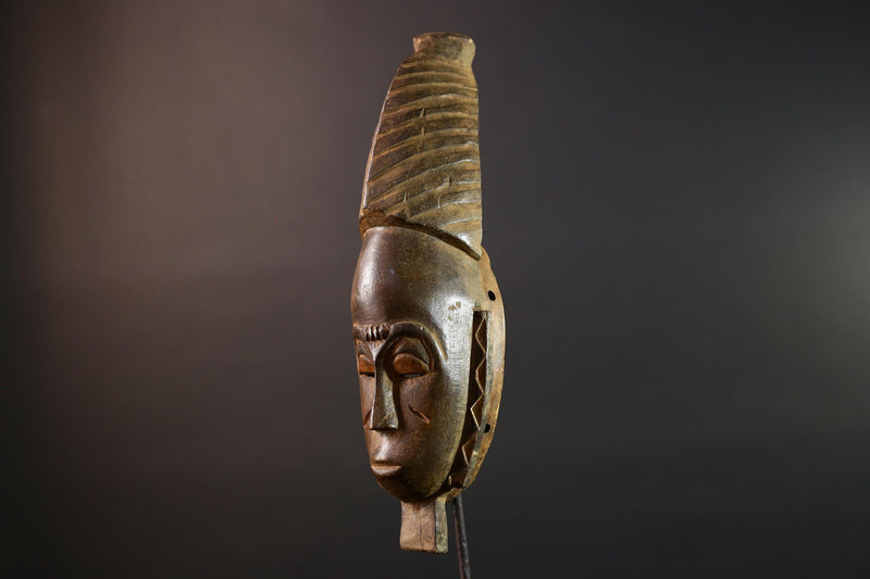 African mask Baule tribal art with long oval face, downcast eyes, vertical ridged crest, and carved cheek marks wall decor sculpture G5573