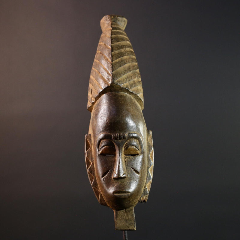 African mask Baule tribal art with long oval face, downcast eyes, vertical ridged crest, and carved cheek marks wall decor sculpture G5573