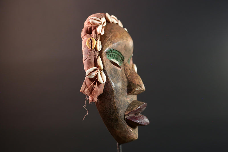 African mask Dan cowrie headdress with green eyelids, red lips, and carved wood female spirit face from Côte d’Ivoire wall art G5575