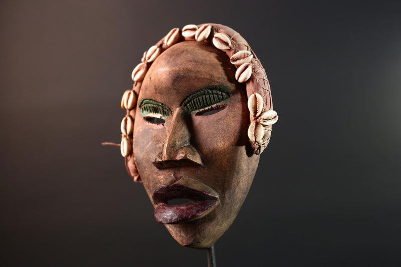 African mask Dan cowrie headdress with green eyelids, red lips, and carved wood female spirit face from Côte d’Ivoire wall art G5575