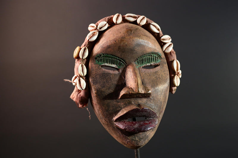 African mask Dan cowrie headdress with green eyelids, red lips, and carved wood female spirit face from Côte d’Ivoire wall art G5575