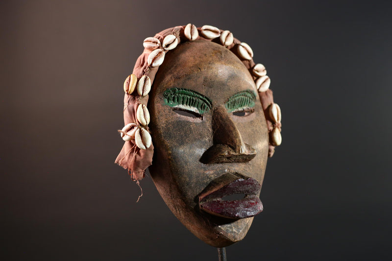 African mask Dan cowrie headdress with green eyelids, red lips, and carved wood female spirit face from Côte d’Ivoire wall art G5575