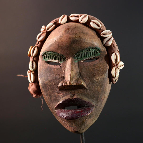 African mask Dan cowrie headdress with green eyelids, red lips, and carved wood female spirit face from Côte d’Ivoire wall art G5575